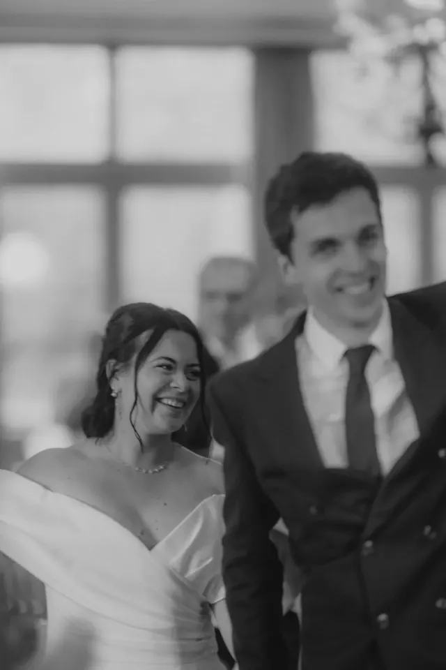 Mariée éclatant de rire aux côtés de son marié pendant la soirée, en noir et blanc, au Domaine des Bouleaux à Seneffe