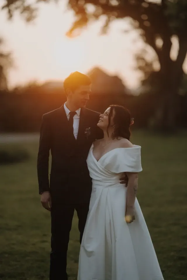 Mariés face à face dans la lumière du soleil couchant, séance couple au Domaine des Bouleaux à Seneffe