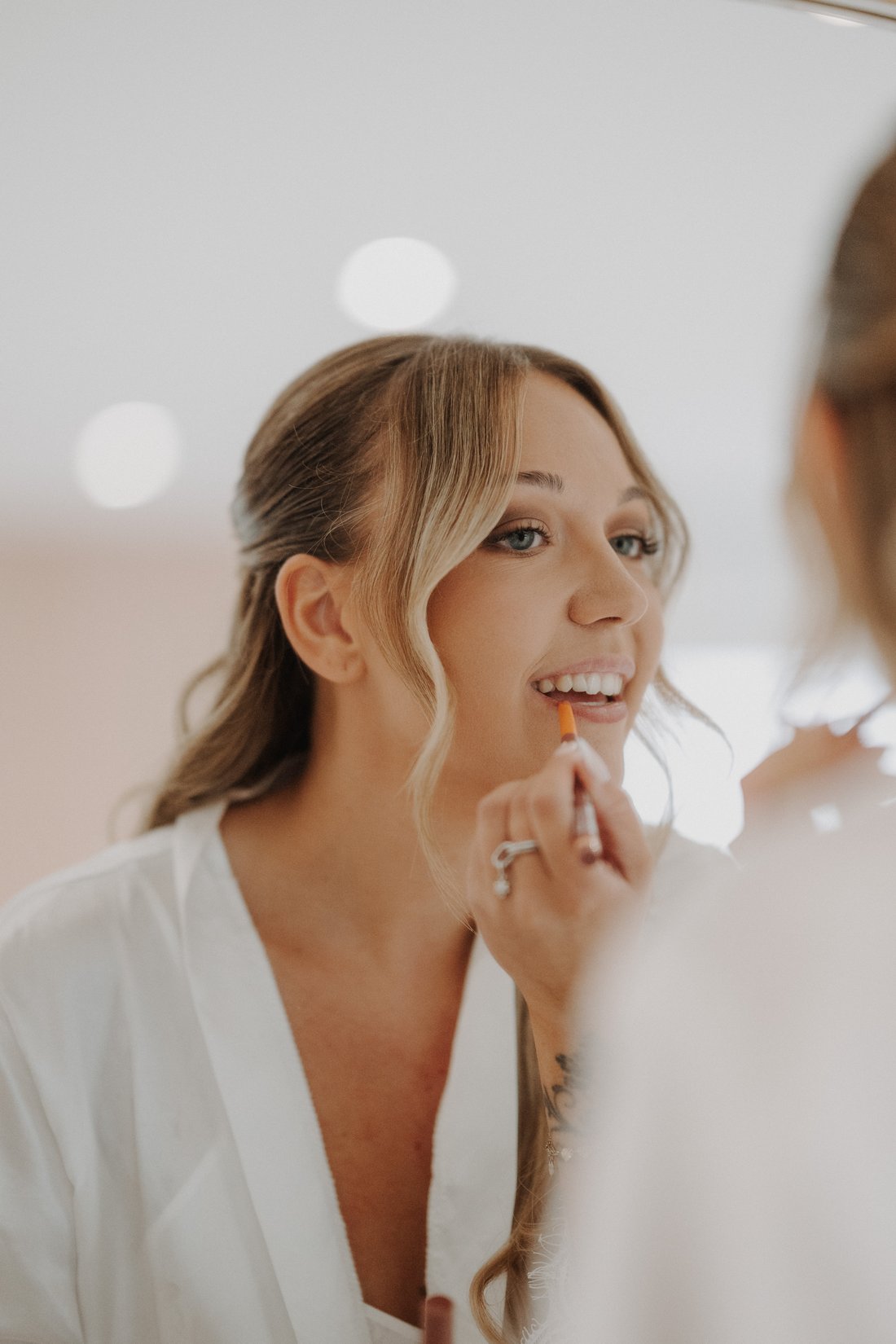 Mariée appliquant son rouge à lèvres face au miroir — préparatifs intimes, photographe mariage Lille