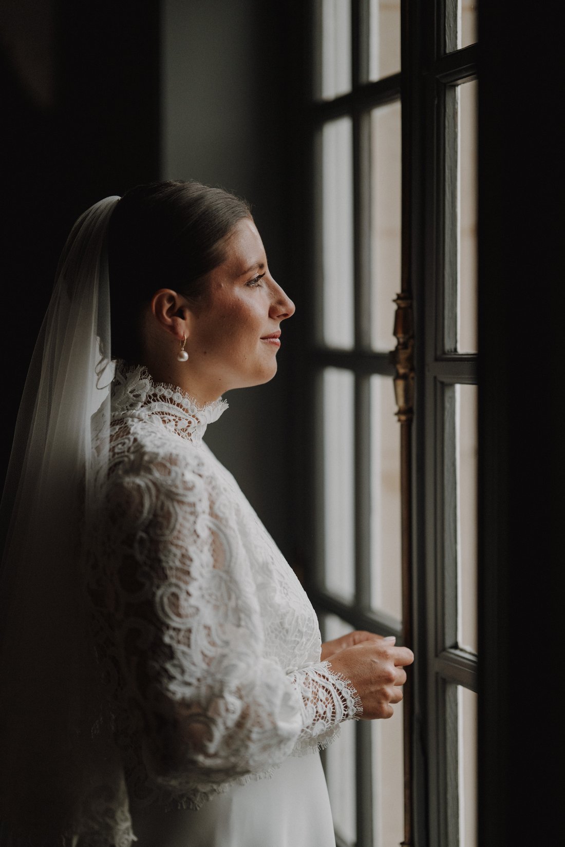 Mariée en dentelle ancienne à la fenêtre, château — portrait éditorial mariage Flandres