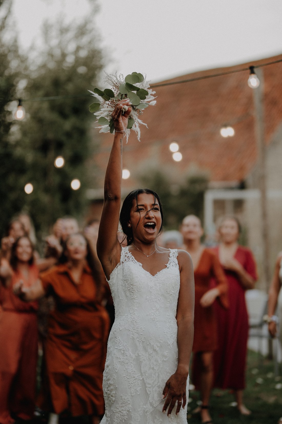 Mariée brandissant son bouquet d'eucalyptus — lancer de bouquet, mariage en plein air