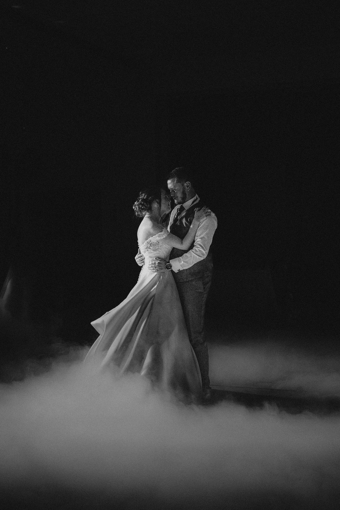 Première danse en noir et blanc avec fumée basse — soirée de mariage cinématographique