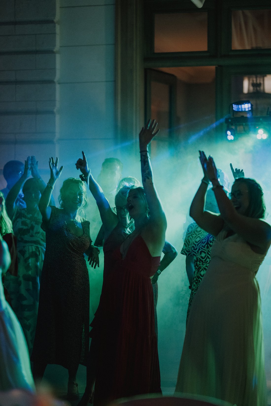 Soirée dansante éclairée en lumière verte sur invités joyeux — mariage festif Lille