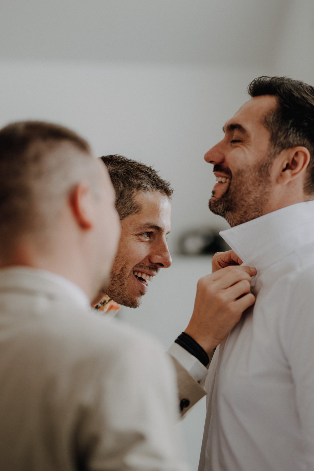 Garçons d'honneur en train d'aider le marié à s'habiller — préparatifs amitié, reportage mariage